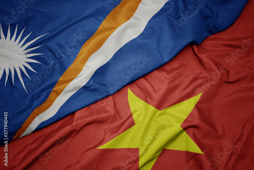 waving colorful flag of vietnam and national flag of Marshall Islands .