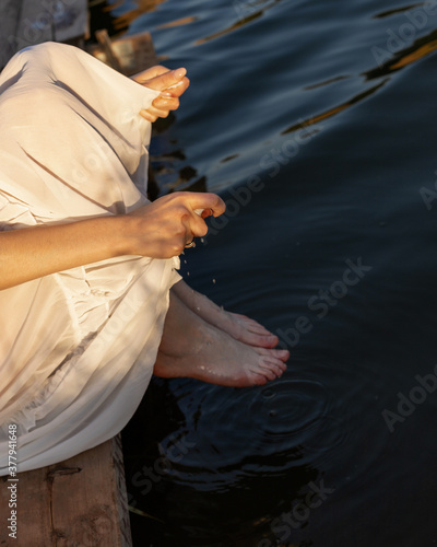
Girl wringing out a dress by the river