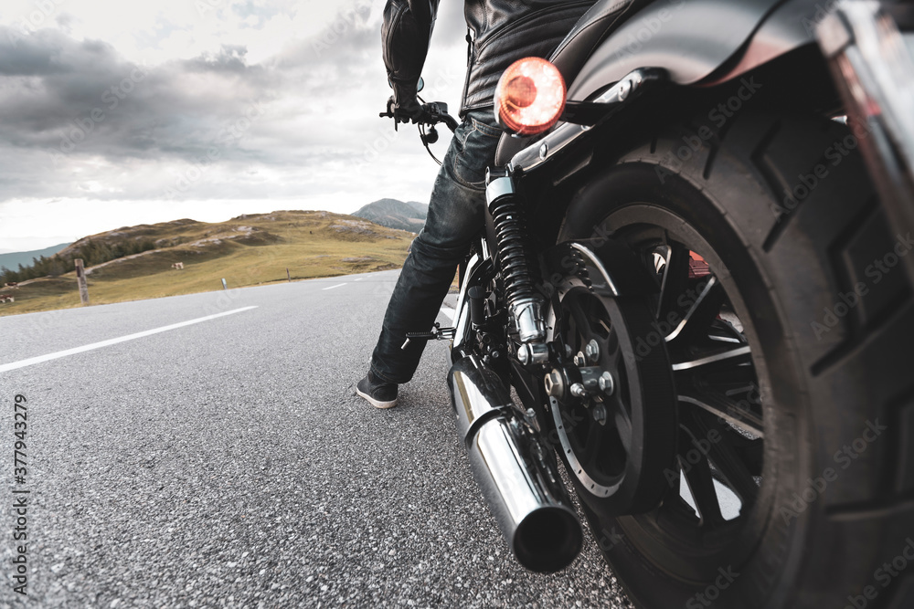 Obraz premium Driver riding motorcycle on an asphalt road in mountain