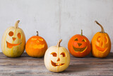 Halloween pumpkins on wooden table on background old white wall