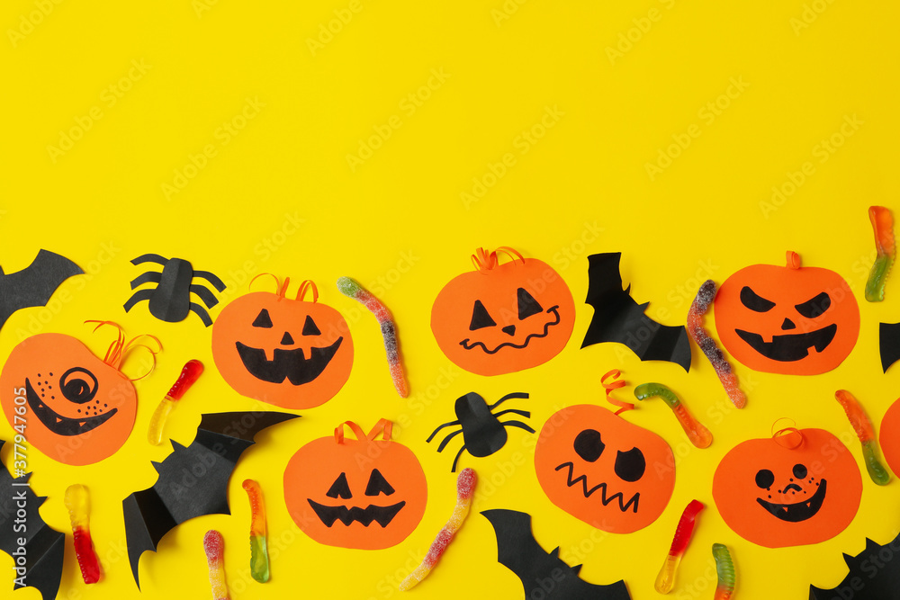 Concept of halloween with paper pumpkins on yellow background Concept of halloween with paper pumpkins on yellow background
