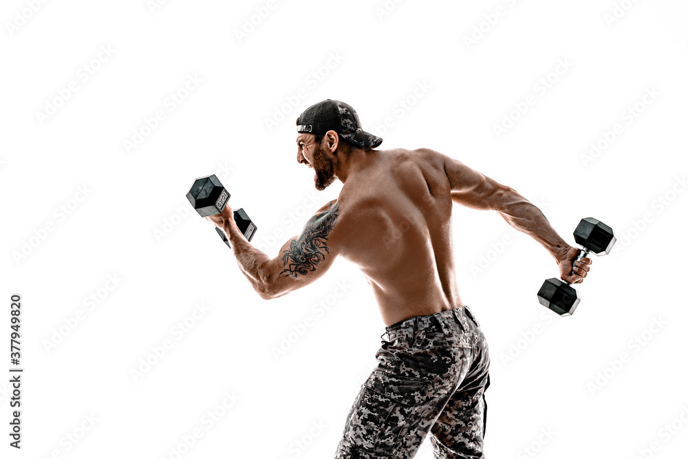 Muscular athlete bodybuilder man in camouflage pants with a naked torso punching with dumbbells like boxer on a white background. Muscular athlete bodybuilder man in camouflage pants with a naked torso punching with dumbbells like boxer on a white background.