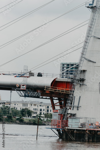 close up of a new cable-stayed bridge is building connecting Thu Thiem peninsula and District 1 across the Saigon River.