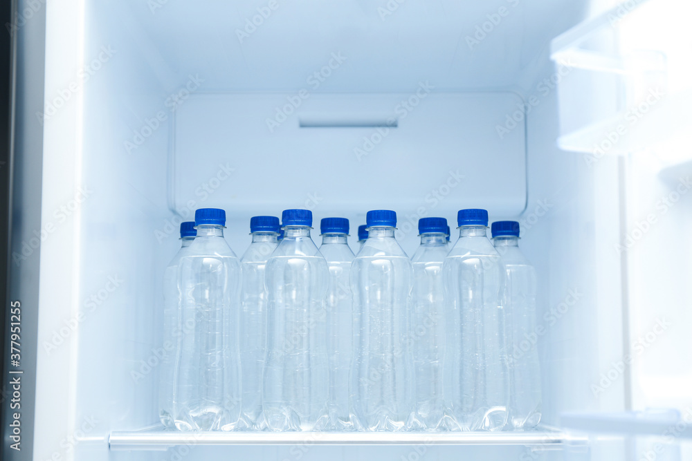 Bottles of pure water on shelf inside refrigerator Bottles of pure water on shelf inside refrigerator