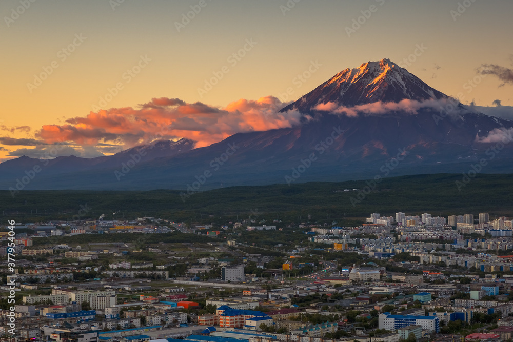 Petropavlovsk-Kamchatsky city at sunset and cone of Koryak volcano. Kamchatka Peninsula, Russia