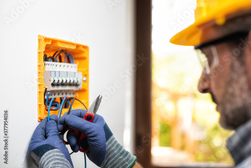 Φωτογραφία Electrician at work with safety equipment on a residential electrical system