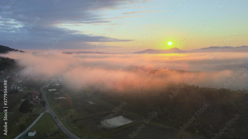Drone fly over a sea of clouds revealing an epic dramatic mountain meditative relaxing landscape during colorful morning sunrise Drone fly over a sea of clouds revealing an epic dramatic mountain meditative relaxing landscape during colorful morning sunrise