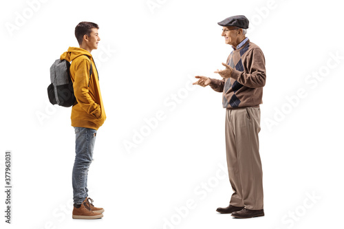 Full length profile shot of an elderly man talking to his teenage grandson