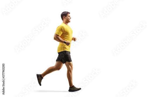 Fototapeta Naklejka Na Ścianę i Meble -  Fit man in a yellow t-shirt and black shorts running