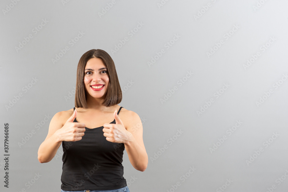 Attractive Turkish woman portrait in positive mood. She is gesturing thumbs up. Attractive Turkish woman portrait in positive mood. She is gesturing thumbs up.