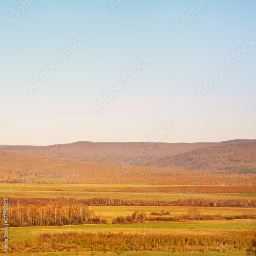 Scenic autumn landscape. meadow, forest and mountains