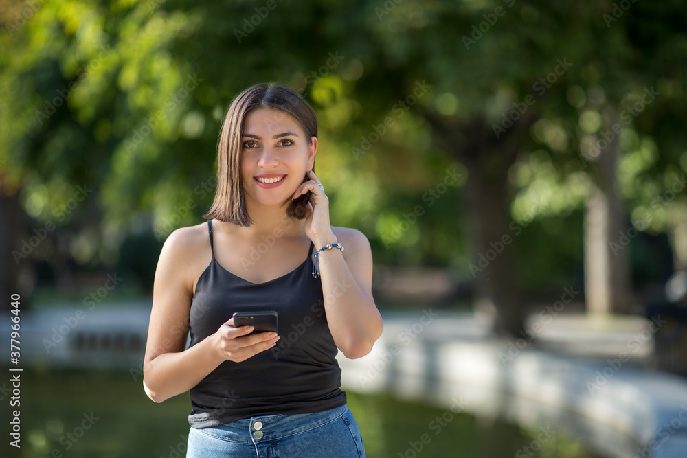 Young beautiful Turkish woman is checking mobile phone while smiling Young beautiful Turkish woman is checking mobile phone while smiling