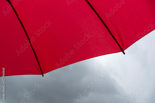 dome  spokes of a red umbrella close-up on a background of gray clouds