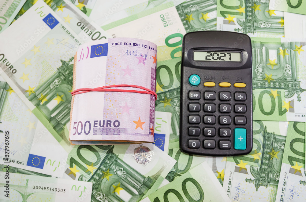folded euro banknotes and calculator on the money background. Euro banknotes tied with elastic band. Financial concept. folded euro banknotes and calculator on the money background. Euro banknotes tied with elastic band. Financial concept.