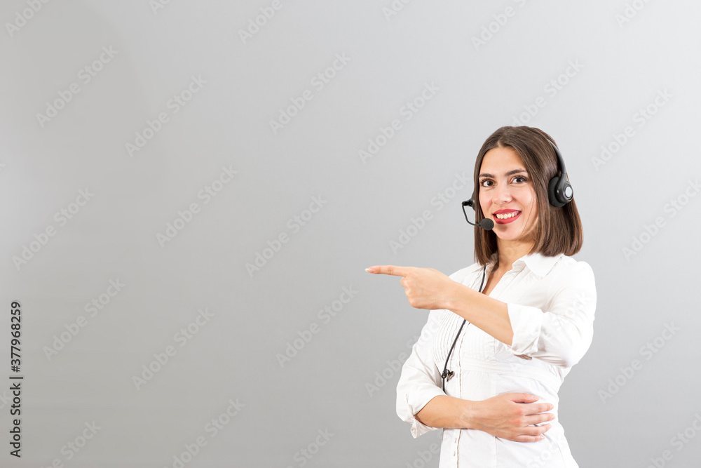 Beautiful Turkish woman with head phone in a studio, isolated shot with copy space, she is pointing the right side Beautiful Turkish woman with head phone in a studio, isolated shot with copy space, she is pointing the right side