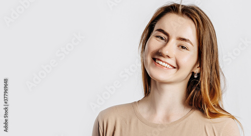 Beautiful young girl smiling and posing looking at the camera on a white isolated background. Positive brunette woman. Kind look. Beauty face.