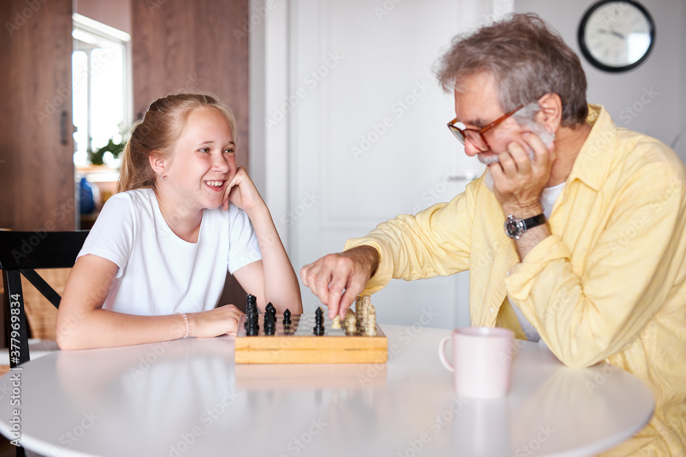 smart grandfather teach granddaughter to play chess, family relationship with granddad and grandchild. grandpa and female grandchild playing board game at home smart grandfather teach granddaughter to play chess, family relationship with granddad and grandchild. grandpa and female grandchild playing board game at home