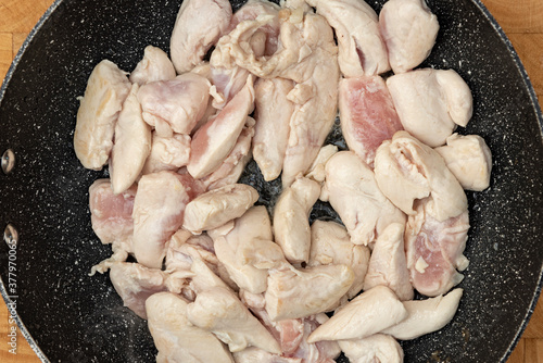 stir fried chicken meat in a deep frying pan