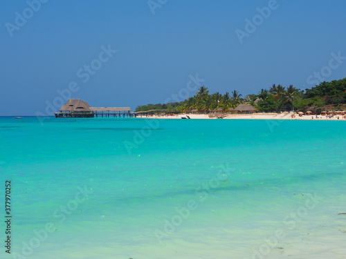 Fototapeta Naklejka Na Ścianę i Meble -  Sunny beach day, white sand, blue Indian ocean in Zanzibar island, Tanzania. Copy space for text.