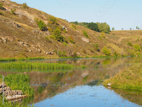 Green grass, river, field and blue sky. Copy space for text.