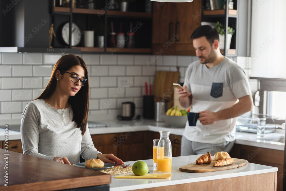 Fototapeta premium Young couple at home kitchen in the morning having relationship problems looking sad