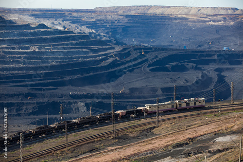 Open pit extraction of coal in quarry"Bogatyr", Ekibastuz, Kazakhstan. Quarry truck, excavators and railroad with cargo train.