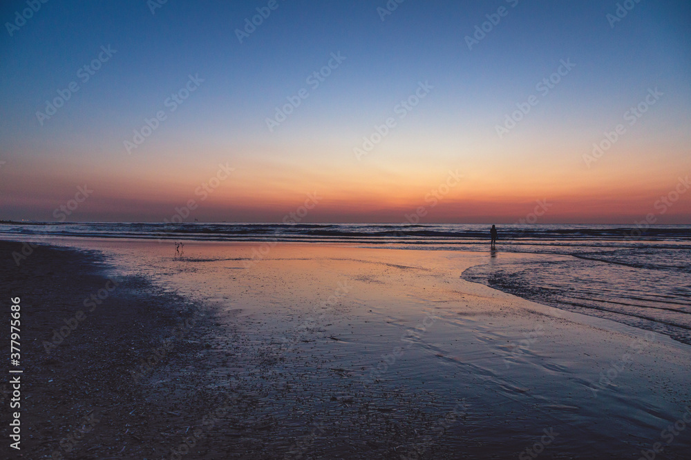 Sunset at North Sea Kijkduin Beach in the Netherlands where the land, sea and sky meet