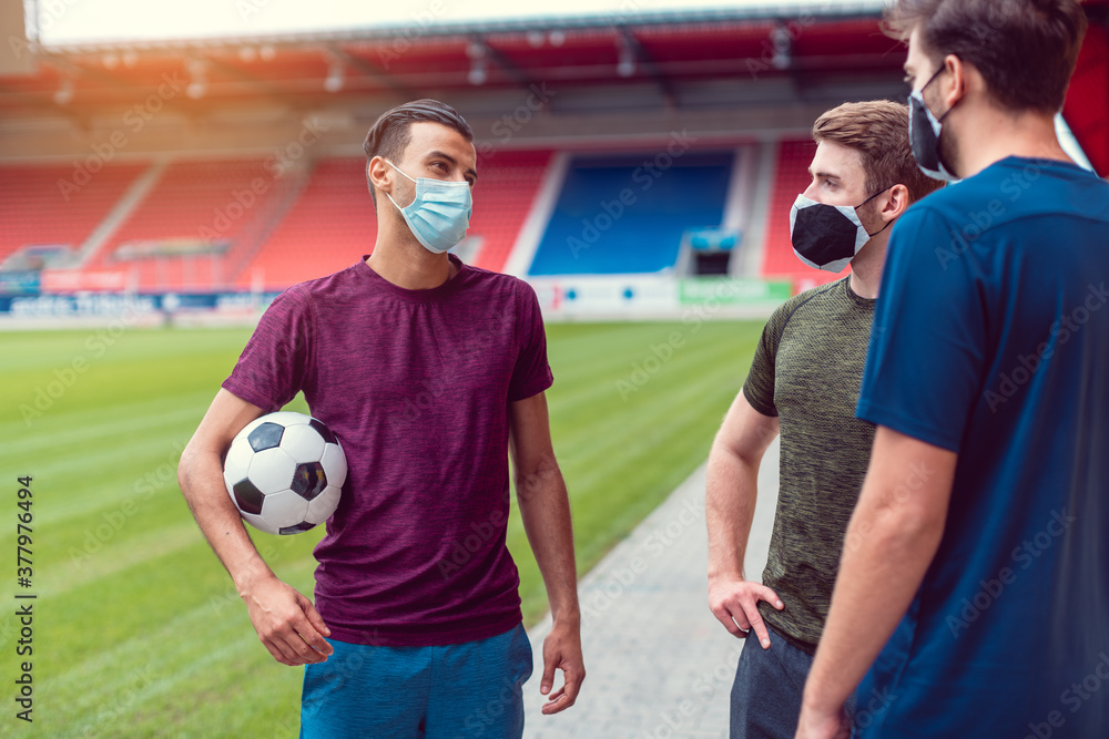 Soccer players in football stadium during covid19 wearing masks Photos