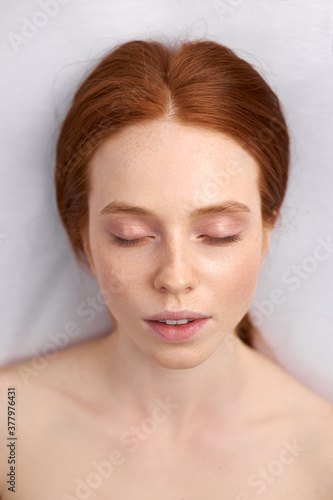 portrait of cute woman before ear piercing, naked lady puts her hair behind her ear and looks away