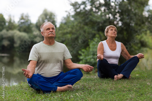 Senior family couple practising meditation outdoors. yoga. Social Distancing. copy space. Mental Health.
