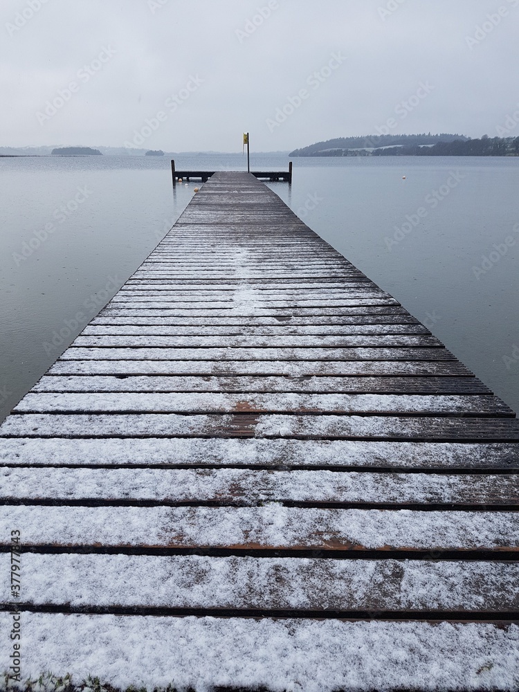pier on the lake with snow