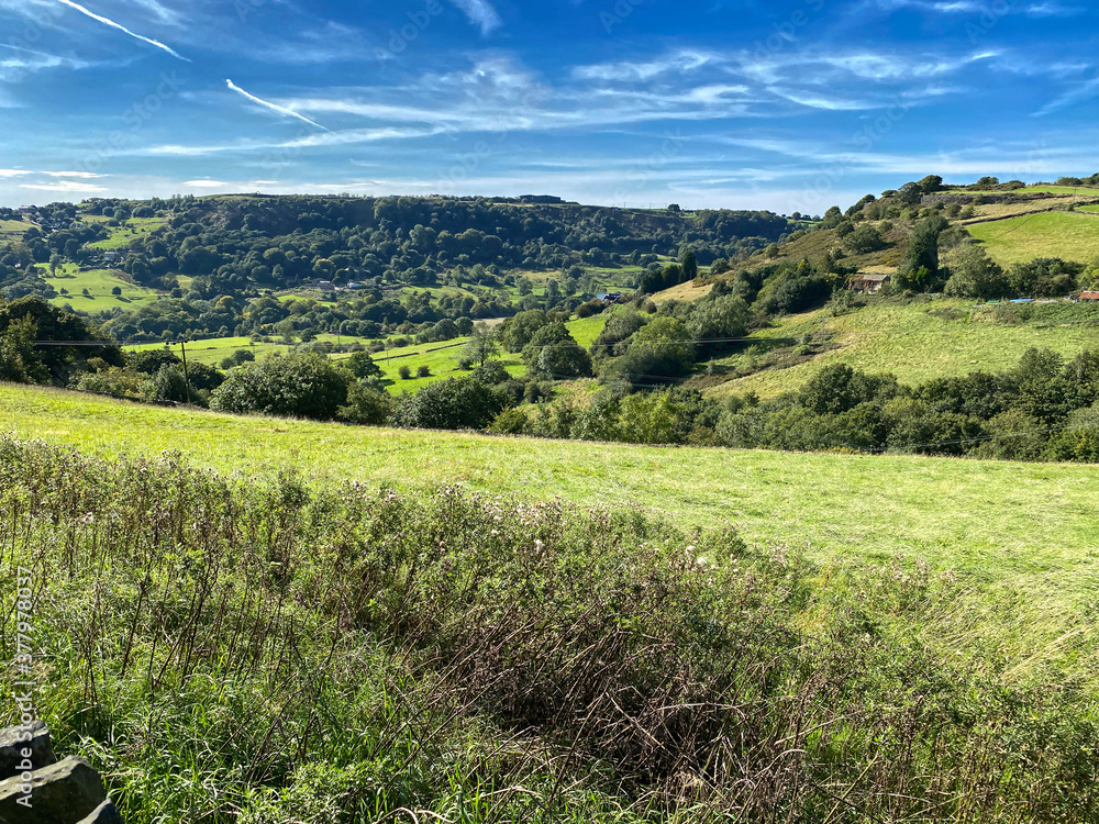 Landscape view, across Shibden Valley, with trees, fields, meadows and hills, on a sunny day near, Halfax, Yorkshire, UK