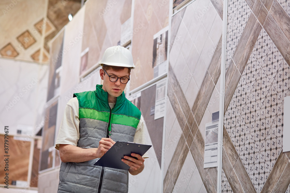 young warehouse worker check quantity of commodity in big market, make notes if something is missing, check up, examine young warehouse worker check quantity of commodity in big market, make notes if something is missing, check up, examine