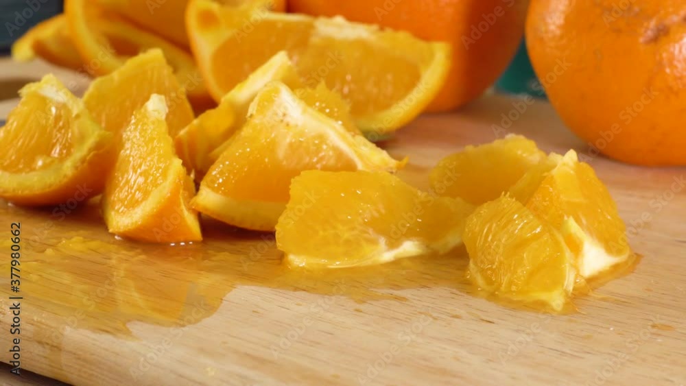 Ripe oranges and orange slices on cutting board