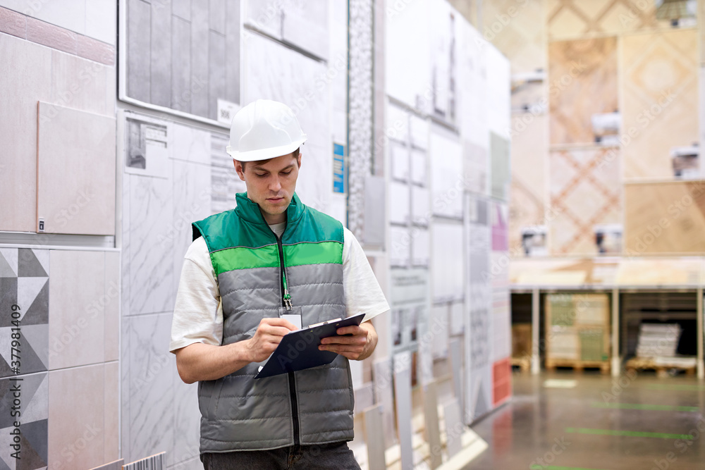 concentrated young warehouse worker in production department of modern store, take notes. export, logistics concept concentrated young warehouse worker in production department of modern store, take notes. export, logistics concept