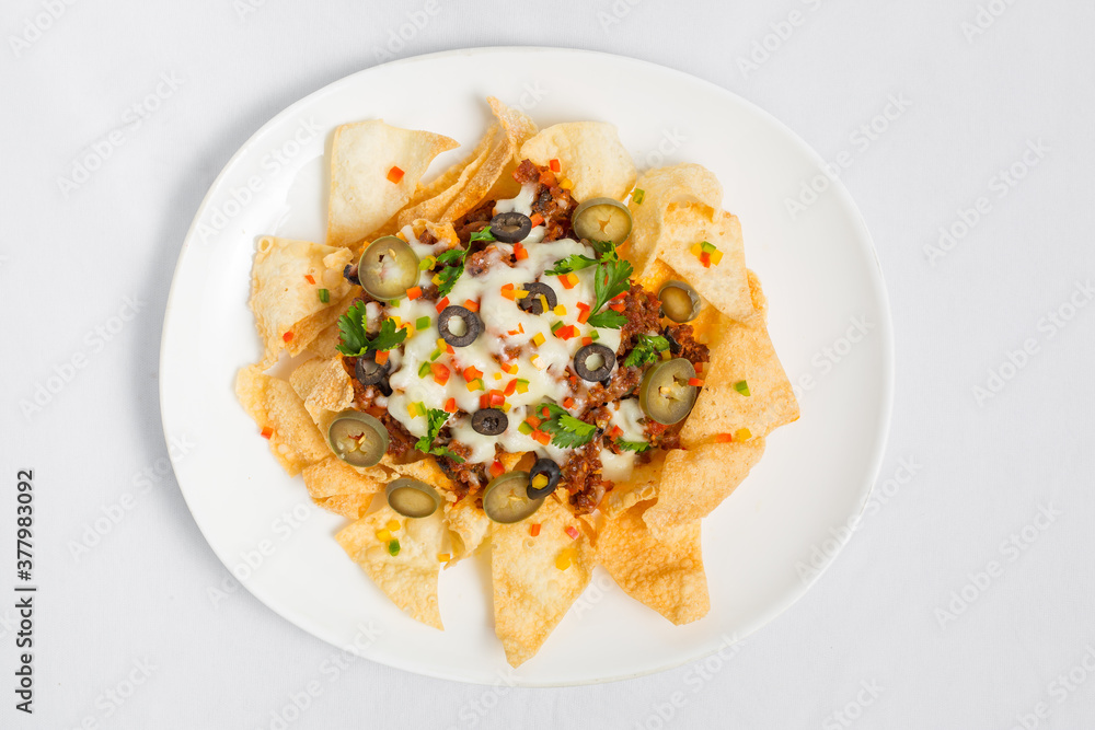 Mexican Famous Food Spicy Ground Beef Nachos. Heated crunchy tortilla chips with melted cheese and jalapeno served a snack food. Mexican Famous Food Spicy Ground Beef Nachos. Heated crunchy tortilla chips with melted cheese and jalapeno served a snack food.