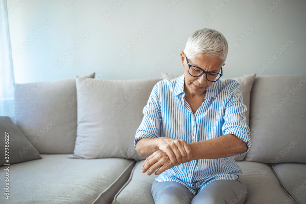 Photo of Elderly lady is enduring strong ache while sitting on the sofa during the day. Senior Woman At Home Suffering With Arthritis. Upset stressed mature middle-aged woman feeling pain ache. Photo of Elderly lady is enduring strong ache while sitting on the sofa during the day. Senior Woman At Home Suffering With Arthritis. Upset stressed mature middle-aged woman feeling pain ache.