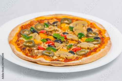 Closeup of Chicken mushroom jalapeno and red pepper pizza on white plate isolated on white background. Homemade Pizza.