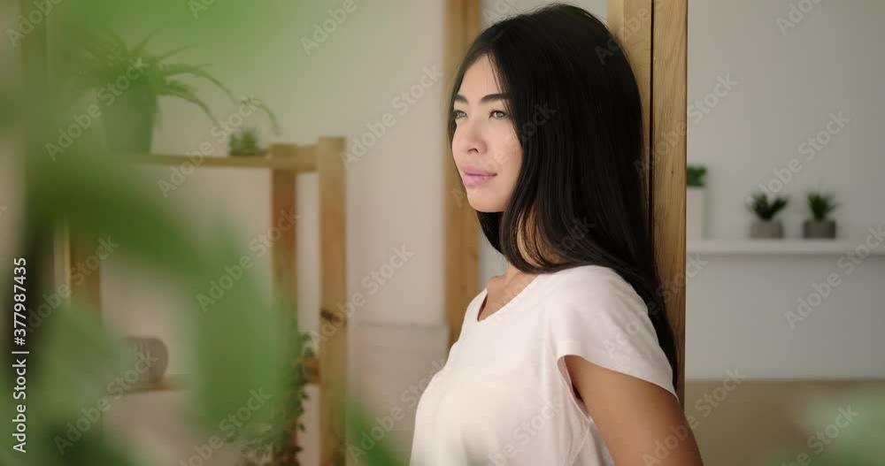 Pleased woman looking away and smiling at home Pleased woman looking away and smiling at home