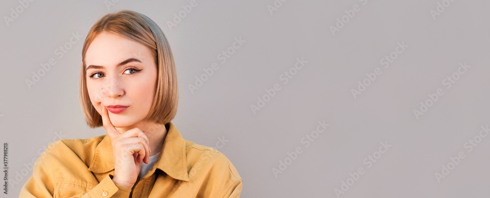 Portrait of a beautiful young woman thinking, isolated on gray background Portrait of a beautiful young woman thinking, isolated on gray background