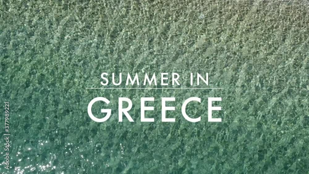 close up of a turquoise greek sea shimmering in the sunlight with the text summer in Greece close up of a turquoise greek sea shimmering in the sunlight with the text summer in Greece