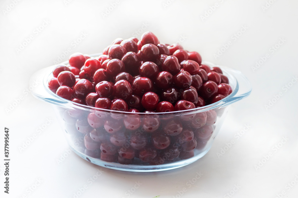 Fresh ripe cherry in a plate on the white background. Top view, copy space. Harvesting red cherries in season. Fresh ripe cherry in a plate on the white background. Top view, copy space. Harvesting red cherries in season.