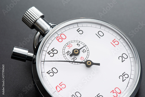 Analogue metal stopwatch on the black background.