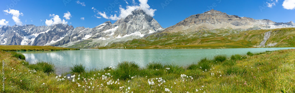 les rives d'un lac bleu de montagne en altitude avec une chaine de montagne et le Cervin en arrière plan