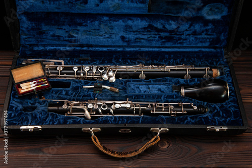 English horn or oboe in a case with reeds for playing on a wooden surface
