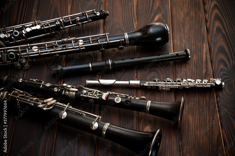 Naklejka premium Woodwind instruments lie on a wooden surface