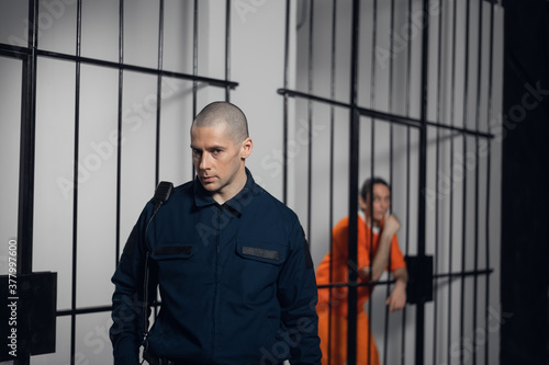 Foto A strict prison guard in uniform guards cells with prisoners in a maximum securi