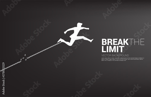 Silhouette of businessman jump to break the chain at foot. Concept of break the rule and limit in business.