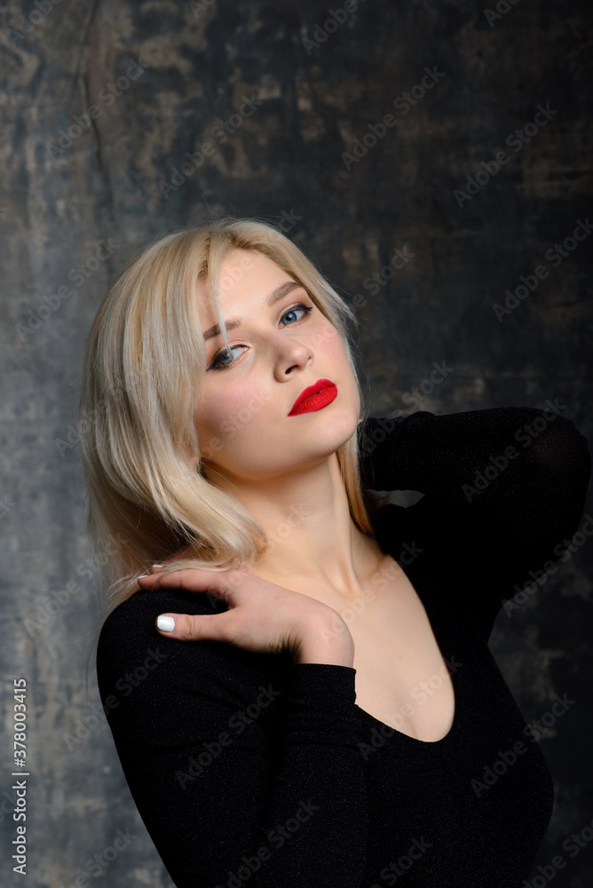 Young blonde plump woman with bright makeup in black bodysuit at dark background Young blonde plump woman with bright makeup in black bodysuit at dark background