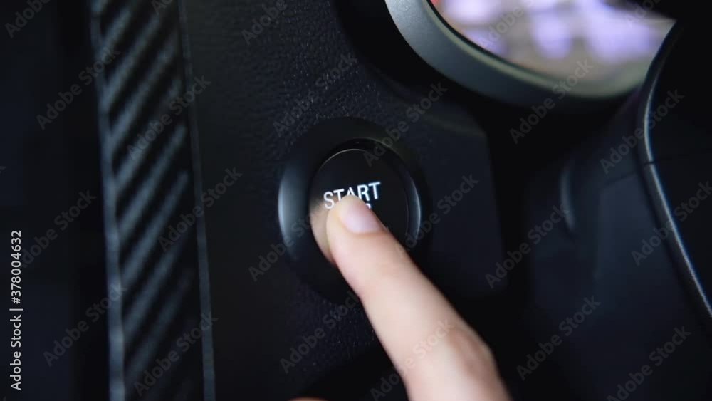 stopping the engine of a car.Finger press the button to stop the car engine with hand held. stopping the engine of a car.Finger press the button to stop the car engine with hand held.